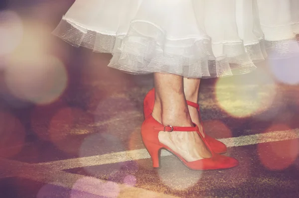 Idosa dançando com sapatos vermelhos e vestido branco — Fotografia de Stock