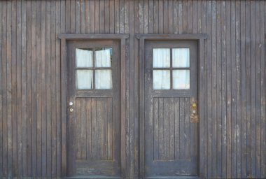 Ahşap arka planda buzlu pencereli iki kapı.