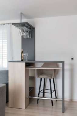 Modern evin oturma odasında bar taburesi ve ahşap masa.