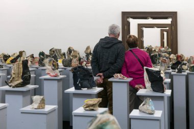 BRATISLAVA, SLOVAKIA - 8 Ocak 2020: Bratislava, Slovakya Şehir Galerisi 'ndeki sayısız kitaptan yapılmış heykel ve yerleştirmelere bakan ziyaretçiler