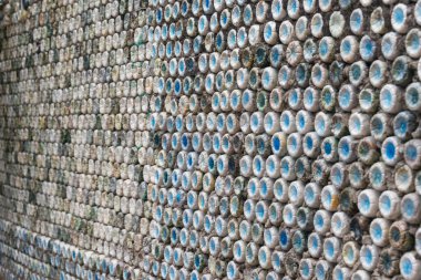 Şişe geri dönüşümü: şişe duvarı oluşturmak için betona sarılmış plastik şişeler