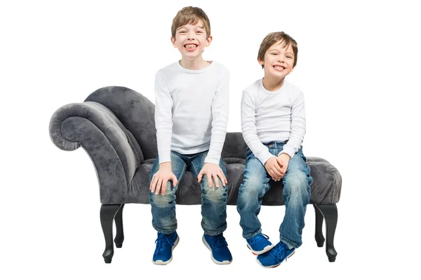 Retrato Dois Meninos Sentados Sofá Mostrando Dentes Isolados Fundo Branco — Fotografia de Stock