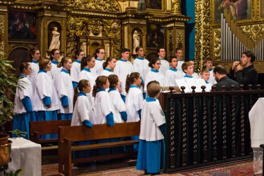LLUC, MALLORCA, SPAIN - OCT 1, 2018: The Blauets of Lluc choir singing in the Basilica within the Monastery of Lluc, Mallorca island, Spain clipart
