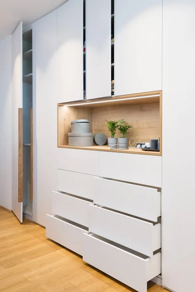 White wooden closet with open shelves in bedroom of modern house