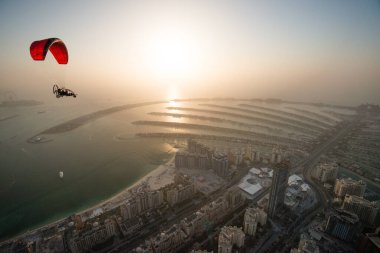 DUBAI, BAE - 16 Şubat 2018: Dubai Marina 'dan kalkan SkyHub Paramotor çift kişilik uçuş Palm Jumeirah, Dubai, BAE, alacakaranlıkta
