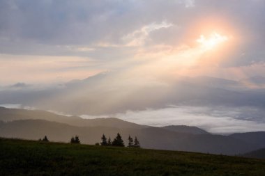 Early morning sun shining through the clouds on top of Martinske hole mountain at Mala Fatra, Slovakia