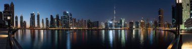 Business Bay 'in panoramik görüntüsü gece suda yansıyor, Dubai, BAE