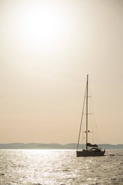 Gün batımında motorlu yelkenli yatının silueti