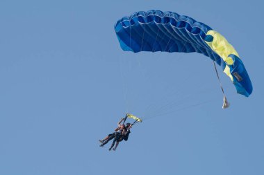 DUBAI, BAE - 16 Şubat 2018: Dubai, BAE 'de paraşütler açık ve mavi gökyüzü ile paraşütle atlama yapan ikili paraşütçüler