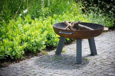 Bahçenin bahçesindeki portatif şömine. Akşam barbeküsü için bir yer.