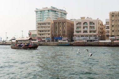 DUBAI, BAE - 14 Şubat 2018: Dubai Deresi boyunca seyahat eden turistlerle Abra feribotu. Dubai deresi şehri Deira ve Bur Dubai 'ye bölüyor..