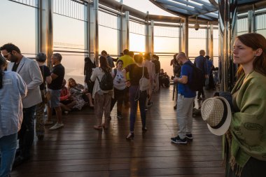 DUBAI, BAE - 17 Şubat 2018: Turistler dünyanın en yüksek binası olan Burj Halife 'nin gözlem güvertesinde gün doğumuna bakıyorlar, Birleşik Arap Emirlikleri