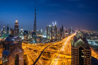 DUBAI, BAE - 19 Şubat 2018: Dubai silueti güneş doğarken Burj Halife ile, dünyanın en yüksek binası ve Şeyh Zayed karayolu trafiği, BAE