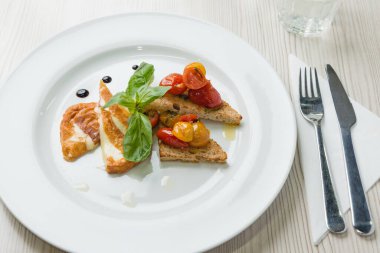 Lezzetli tost sandviçleri, kızarmış peynir, domates, zeytinyağı ve fesleğen.