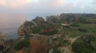 Alacakaranlıkta Portekiz, Algarve 'deki Lagos yakınlarındaki kayalık sahil şeridine ait hava görüntüleri.