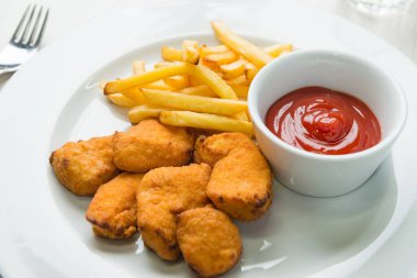 Patates kızartması ve ketçaplı tavuk nugget.
