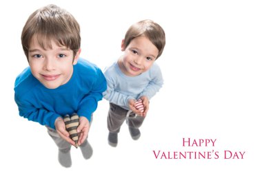 İki kardeş kalbi ellerinde tutuyorlar. Beyaz bir arkaplanda izole edilmiş