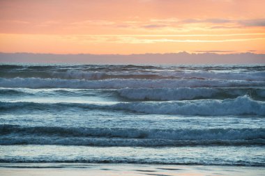Tazman Denizi 'nin üzerinde canlı bir gün batımı. Yeni Zelanda, Kuzey Adası' ndan görüldü.