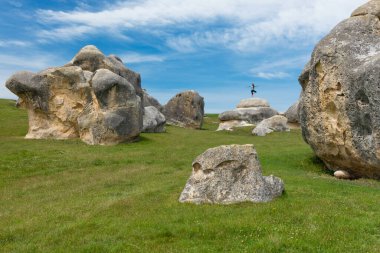 Kuzey Otago, Yeni Zelanda 'da fil kayaları üzerinde poz veren genç bir kadın.