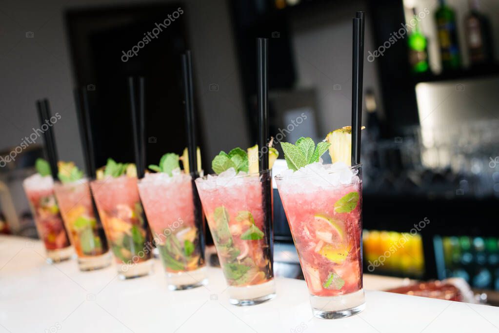 Six cocktails in big glasses on the bar