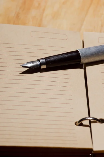 Antigua pluma estilográfica en un cuaderno — Foto de Stock