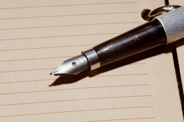 Vecchia penna stilografica su un taccuino — Foto Stock