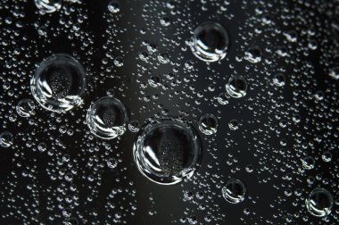 Duvar kağıdı yüzeyine su damlıyor. Siyah ve beyaz. Islak, makro fotoğraf dairesi kalıplarını kapatıyor.