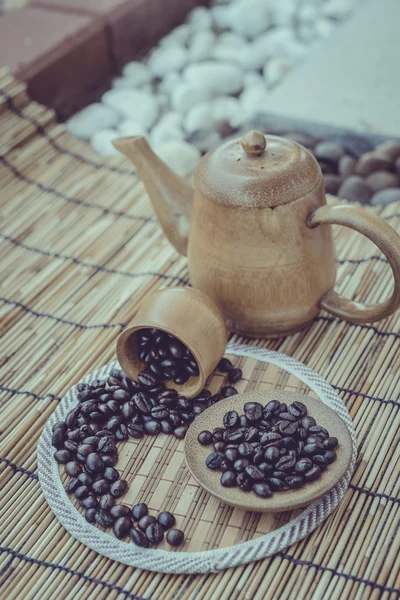 Café frijoles y taza de café sobre fondo de madera de bambú. —  Fotos de Stock