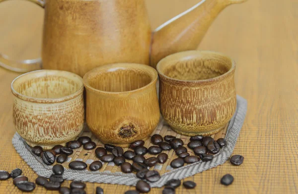 Weichzeichner-Bild von Kaffeebohnen und Kaffeetassen auf Holz — Stockfoto