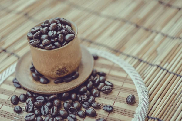 Kaffebönor och kaffekopp på bambu trä bakgrund. Phot — Stockfoto