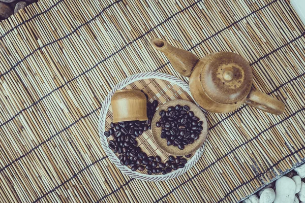 Café frijoles y taza de café sobre fondo de madera de bambú. —  Fotos de Stock