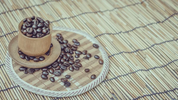 Ziarna kawy i filiżanki kawy na bambus drewniane tła. Fot — Zdjęcie stockowe