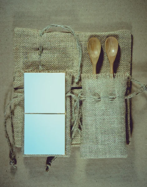 Notatnik i drewnianą łyżką na powierzchni tło worek. — Zdjęcie stockowe