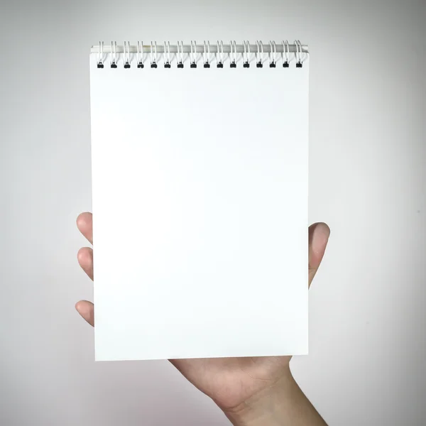 Mujer mano sosteniendo blanco cuaderno en blanco . — Foto de Stock