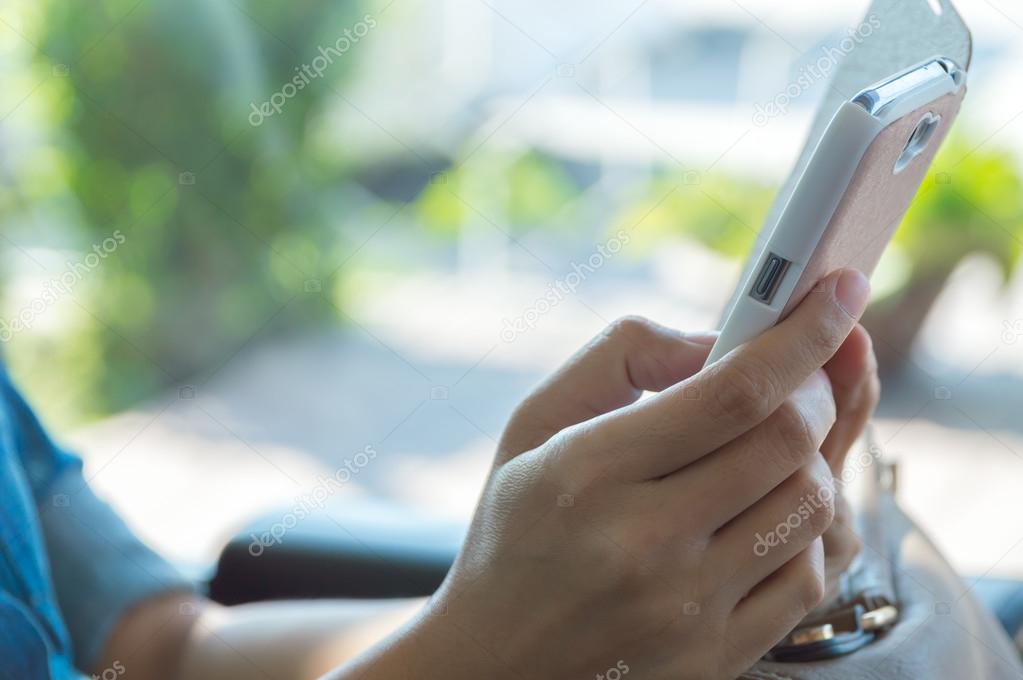 Close up of a young woman using mobile smart phone.