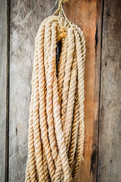 Vecchia tavola di legno con una corda appesa . — Foto Stock