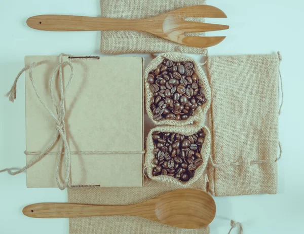 Kaffebönor träsked och gaffel på säck yta. Filtereffekt — Stockfoto
