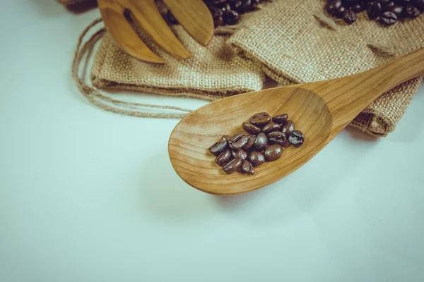 Kaffebönor träsked och gaffel på säck yta. Filtereffekt — Stockfoto