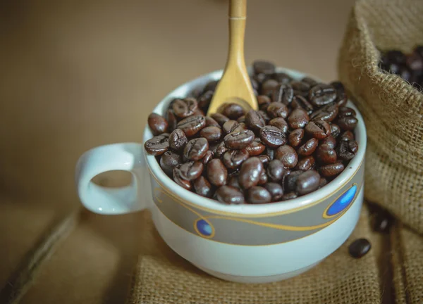 Copa Vintage de granos de café tostados en la superficie del saco, enfoque suave . —  Fotos de Stock