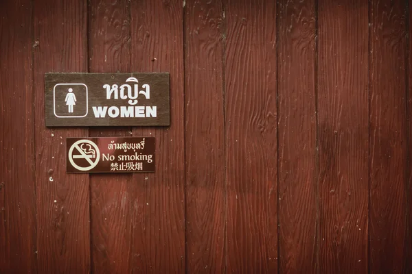 Wanita tanda-tanda toilet Dan tidak merokok tanda-tanda di dinding kayu . Stok Foto