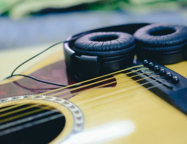 Closeup akustik gitar ve kulaklık.