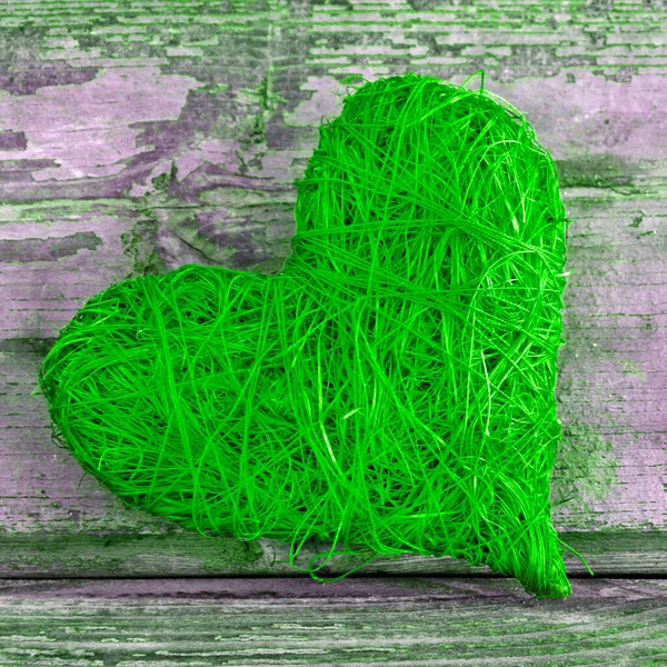Green heart against a wooden background