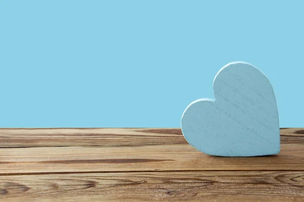 Blue heart and wooden background