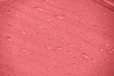 Büyük yağmur damlalarıyla su geçirmez kumaş. Mercan pembesi yırtık önleyici kumaş. Çadır tekstili. Su geçirmez malzeme.