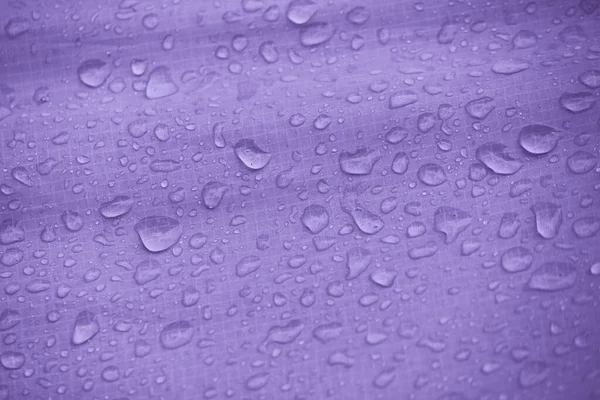 Water-repellent fabric in large raindrops. Rip-stop fabric. Tent textiles. Waterproof material.