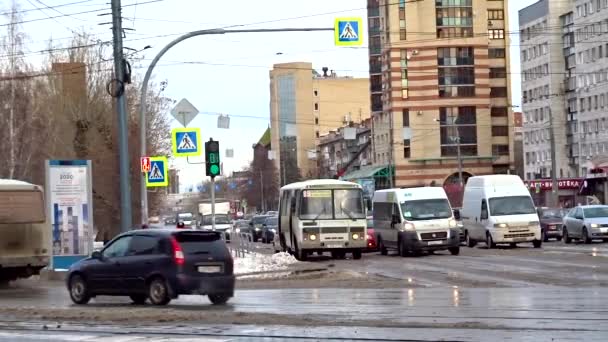 Cseljabinszk, Oroszország - 2020. október 28.: Nedves út, autók állnak egy kereszteződés előtt a piros jelzőlámpánál. És továbblépnek a zöld fény felé, iszapot szórva.. — Stock videók