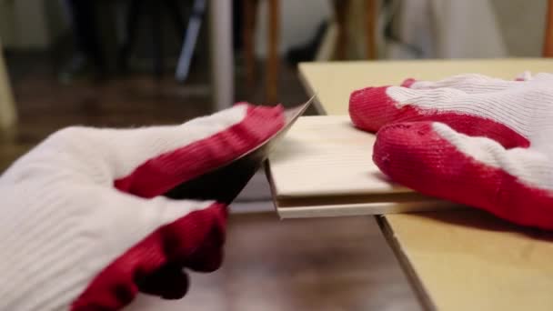 Schuren van de randen van houten dennenplanken met schuurpapier. Handen in het werk handschoenen verwerken hout, timmerwerk. — Stockvideo
