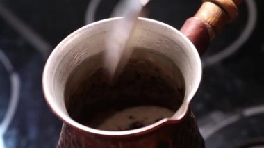 Sade kahve bir çereze doldurulur ve şekerle karıştırılır. Lezzetli bir sıcak içecek pişiriyorum. Bulanık video.