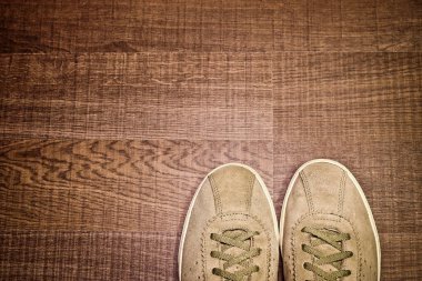 Ahşap zeminde, üst manzaralı, metin için fotokopi alanı olan klasik süet spor ayakkabıları. Seyahat kavramı.