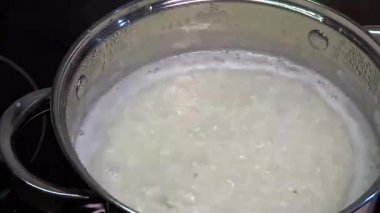 Pirinç bir tencerede pişirilir. Kahvaltıda yulaf lapası yapıyorum. Ana yemekler için meze, öğle yemeği. Kaynar su ve haşlanmış taneler..